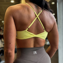 Load image into Gallery viewer, Person wearing a yellow sports bra and gray leggings in a gym setting